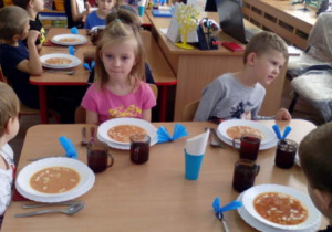 Dzieci siedzące podczas obiadu, do którego samodzielnie nakryły stoły.